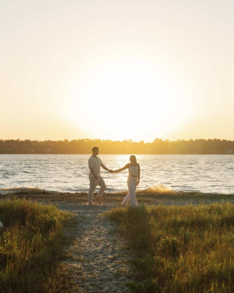couple walking on the beach at golden hour for their engagement photos on hilton head island, sc 